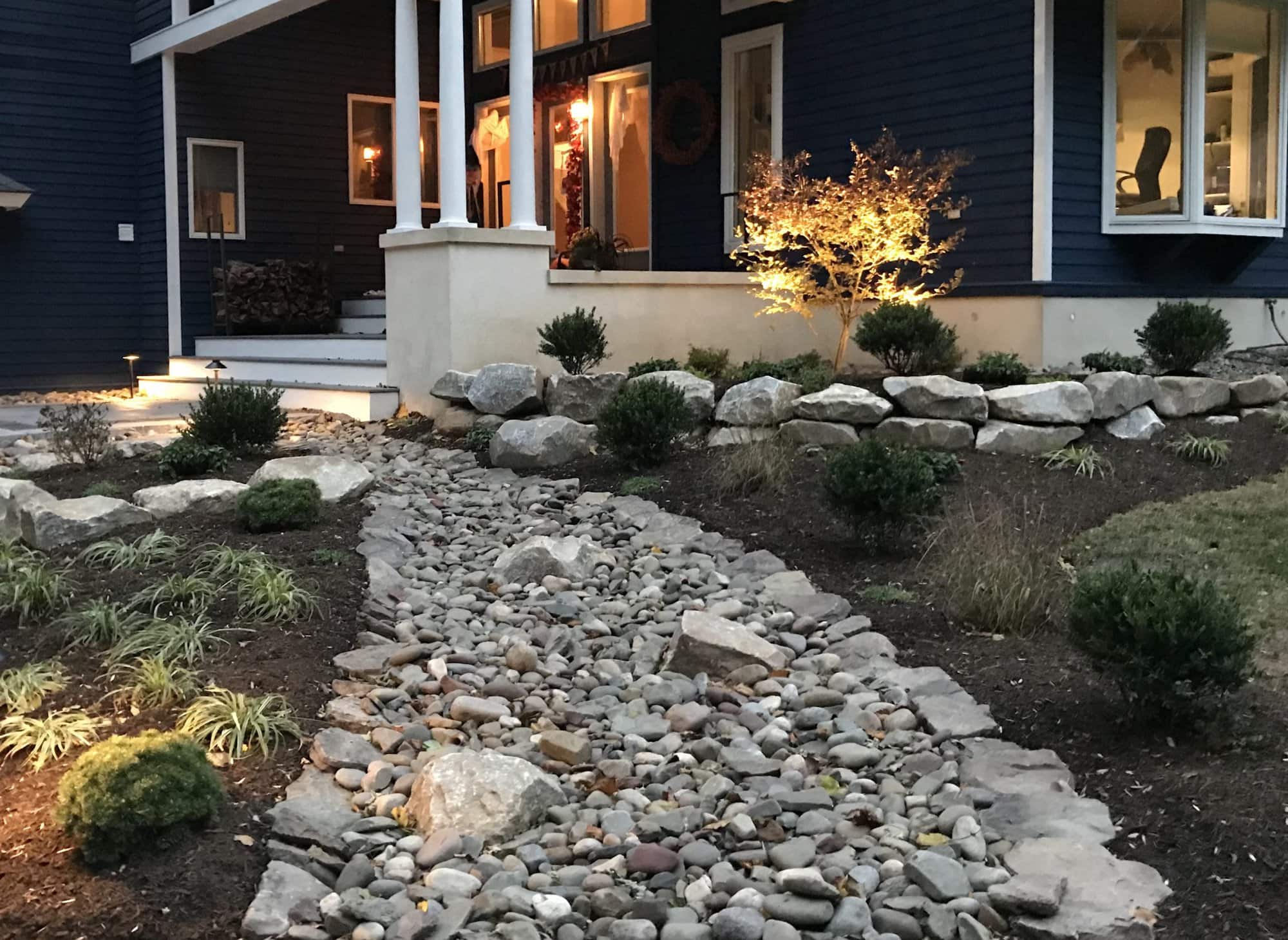 River rock and boulder landscaping around a live oak