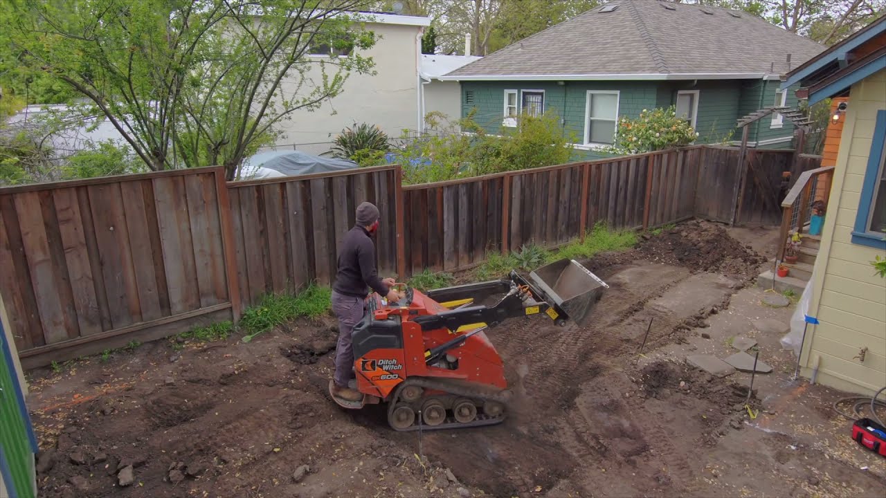 Mini skid steer leveling a San Antonio yard